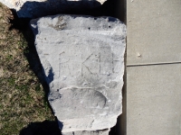 Fragment, ending in RKLE. Chicago lakefront stone carvings, between Belmont and Diversey Harbors. 2019