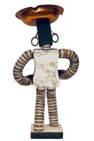 Rear of bottle-cap figure with metal plate on chest, formica plate on back  and notebook reinforcers for eyes and mouth  - vernacular art