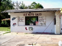 Buy Here Pay Here Florida style. Deteriorating painted facade for D.J. Auto Sales, next to A Auto Repair-Roadside Art