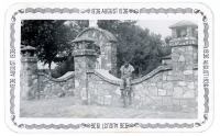 1936 snapshot of boy sitting on a rock fence
