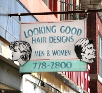 Sign for Looking Good Hair Design with profiles of woman and man