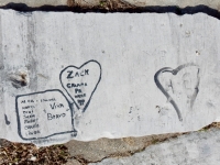 Viva "Bravo," Alma, Norm, Toni, Jackie, Bobby, Charlie, Linda, Emanual, in rectangle, Zack, Gramma, Pa 01, in heart, plus carved heart, with JR and DH and another drawn heart. Chicago lakefront stone carvings, Calumet Park. 2019