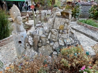 Mound of faces and stuff at Howard Finster's Paradise Garden, 2016. The bottle house is in the background to the right