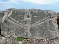 Faces and figure with the sun by Joel Cardenas. The figure is from the Promontory Point workship that he co-led with Roman Villareal in October 2022. He completed the faces and added his Cosmo Teocal signature in May 2023. Level 5, vertical. Chicago lakefront stone carvings, Promontory Point. 2025