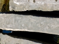 Fancy script, detail. Chicago lakefront stone carvings, Rainbow Beach jetty. 2022