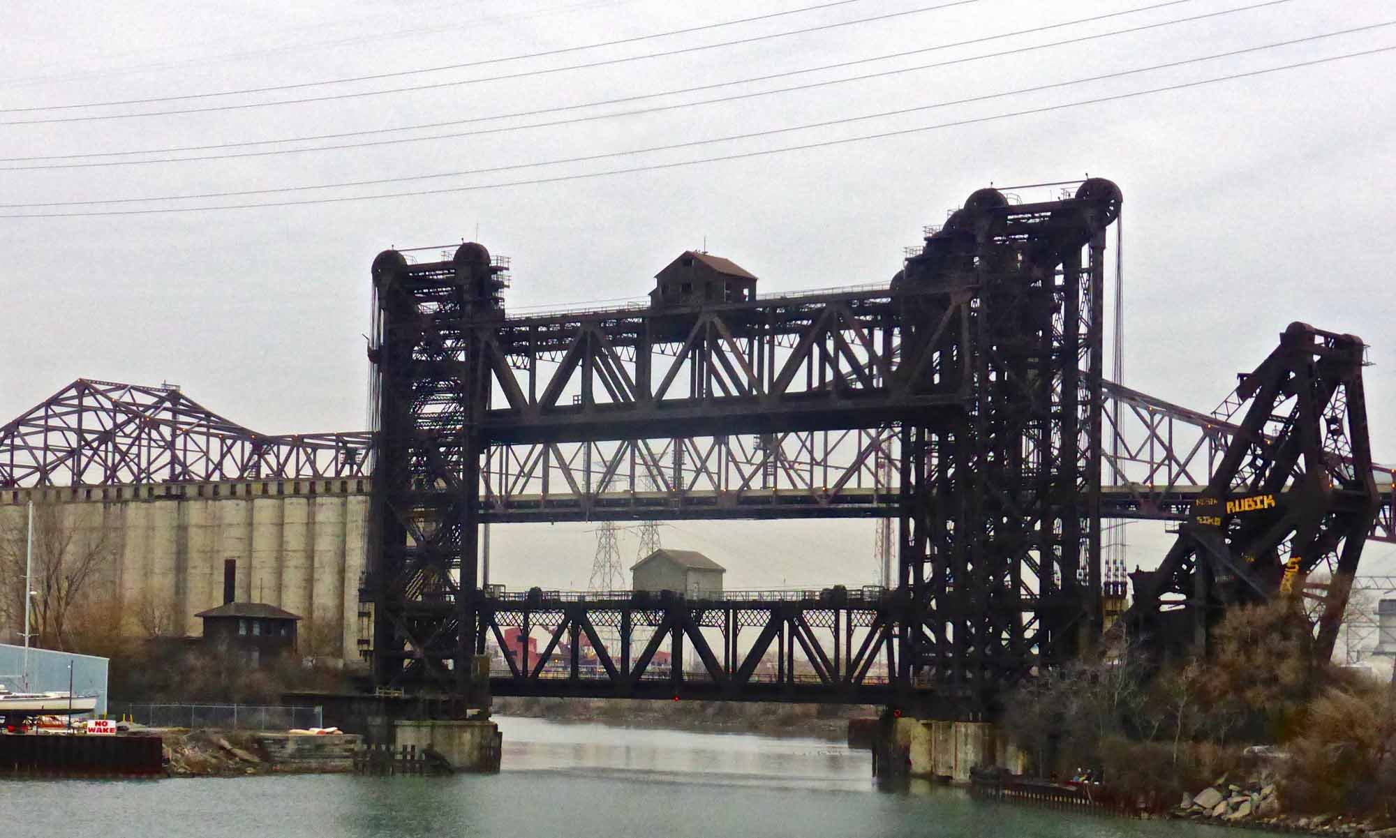 Railroad bridges over the Calumet River, with the Chicago Skyway in the background.